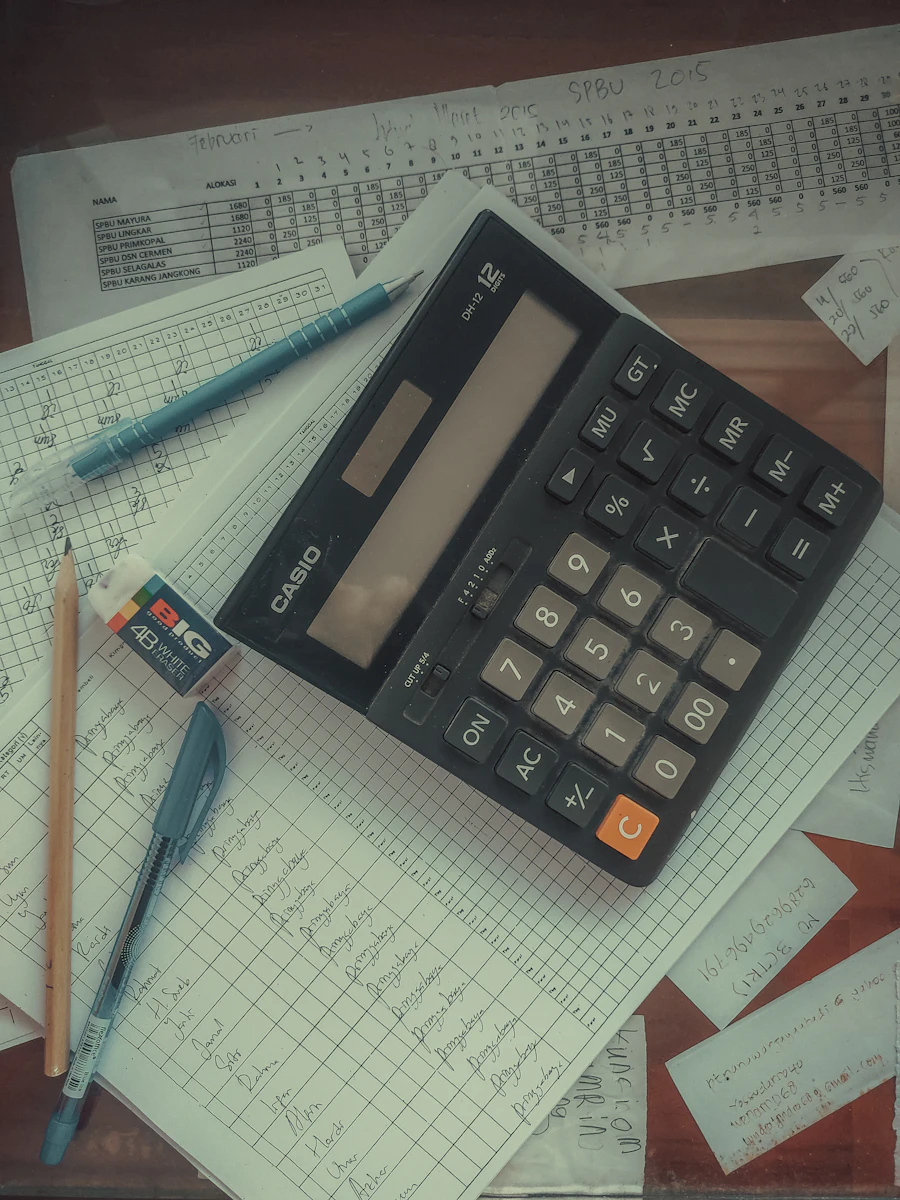 A calculator on a ledger of handwritten figures