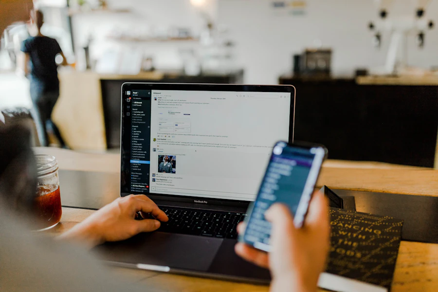 A phone and a laptop open side by side on a desk